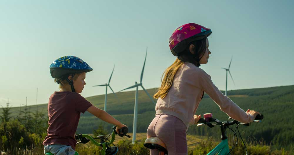 children at the wind farm cycling